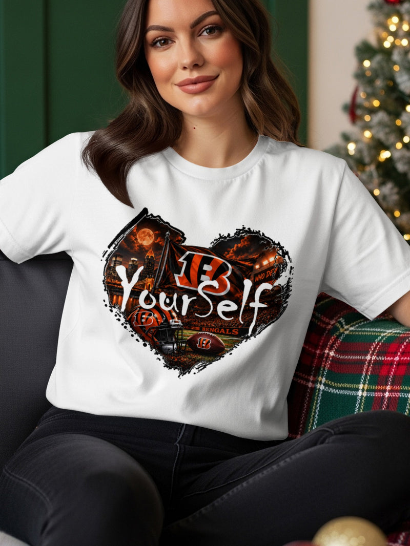 Load image into Gallery viewer, White t-shirt with a heart-shaped graphic featuring the Cincinnati Bengals logo, stadium, and "Be Yourself".
