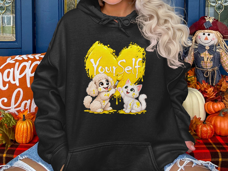 Load image into Gallery viewer, Poodle and cat paint yellow heart with text "Your Self" on black hoodie.
