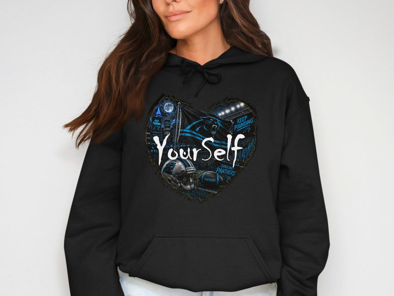 Load image into Gallery viewer, Black hoodie with heart graphic featuring Carolina Panthers logo, helmet, football, and stadium.
