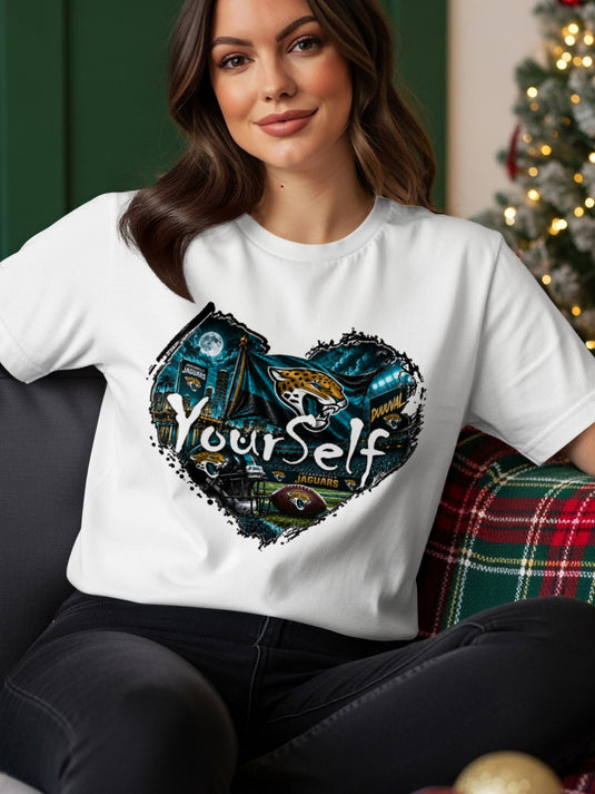 White t-shirt with a heart-shaped graphic featuring Jacksonville Jaguars logos, football, and stadium lights.